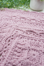 A close-up of a pink crochet square.